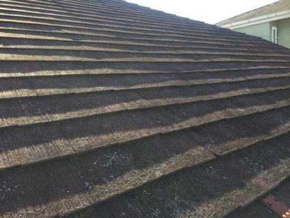 屋根に、経年劣化による色褪せ、苔・塵埃などによる汚れ、塗膜剥離などが確認できます。