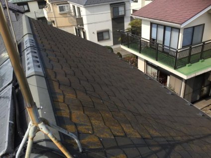 屋根に、経年劣化による色褪せ、苔・塵埃などによる汚れ、ひび割れなどが確認できます。